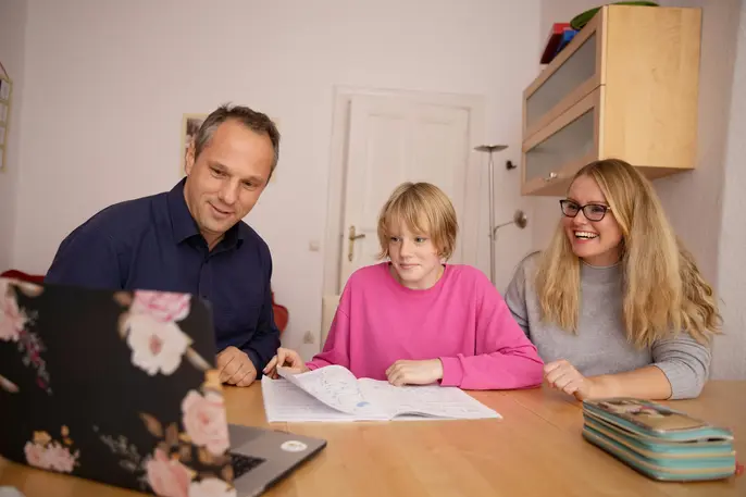 parents using their computer with their teenage child